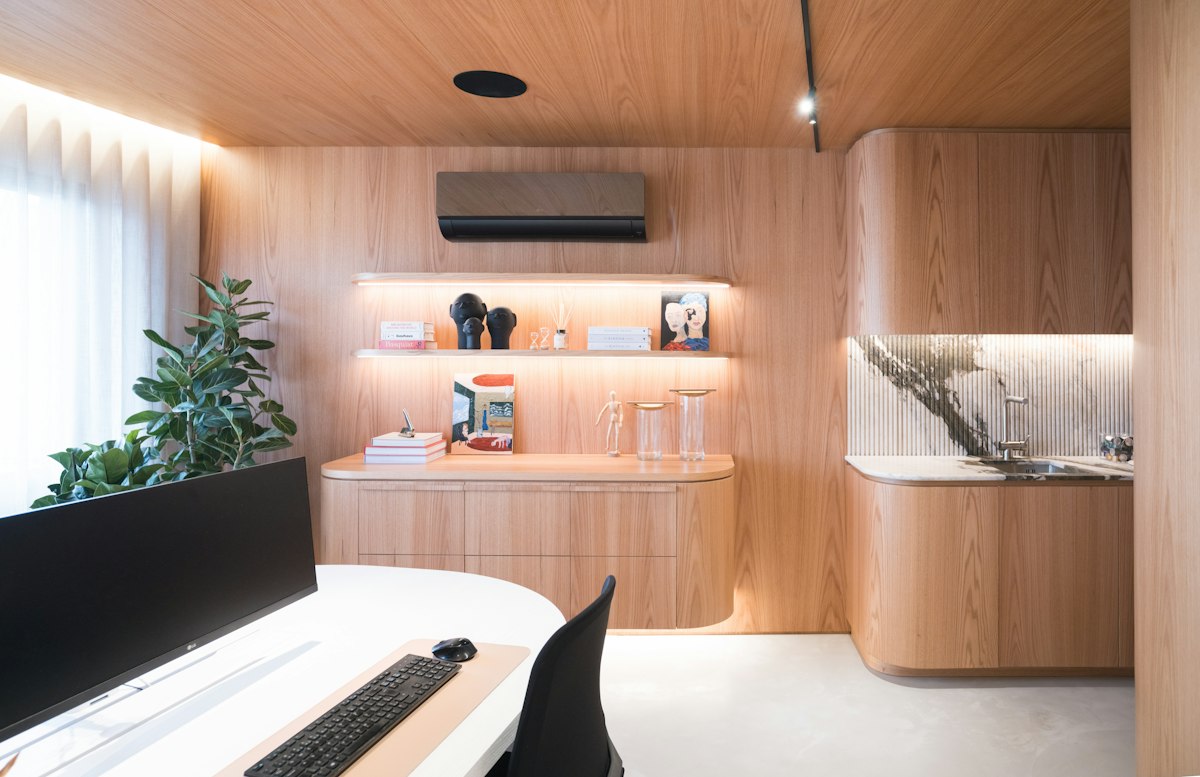 Home office com painéis e nichos em madeira iluminados